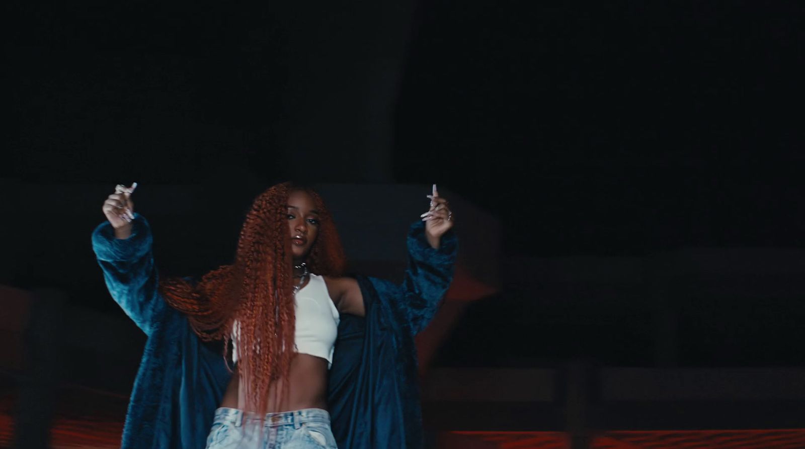 a woman with long red hair holding a cigarette