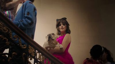 a woman in a pink dress holding a dog