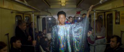 a woman standing on a subway train next to a group of people