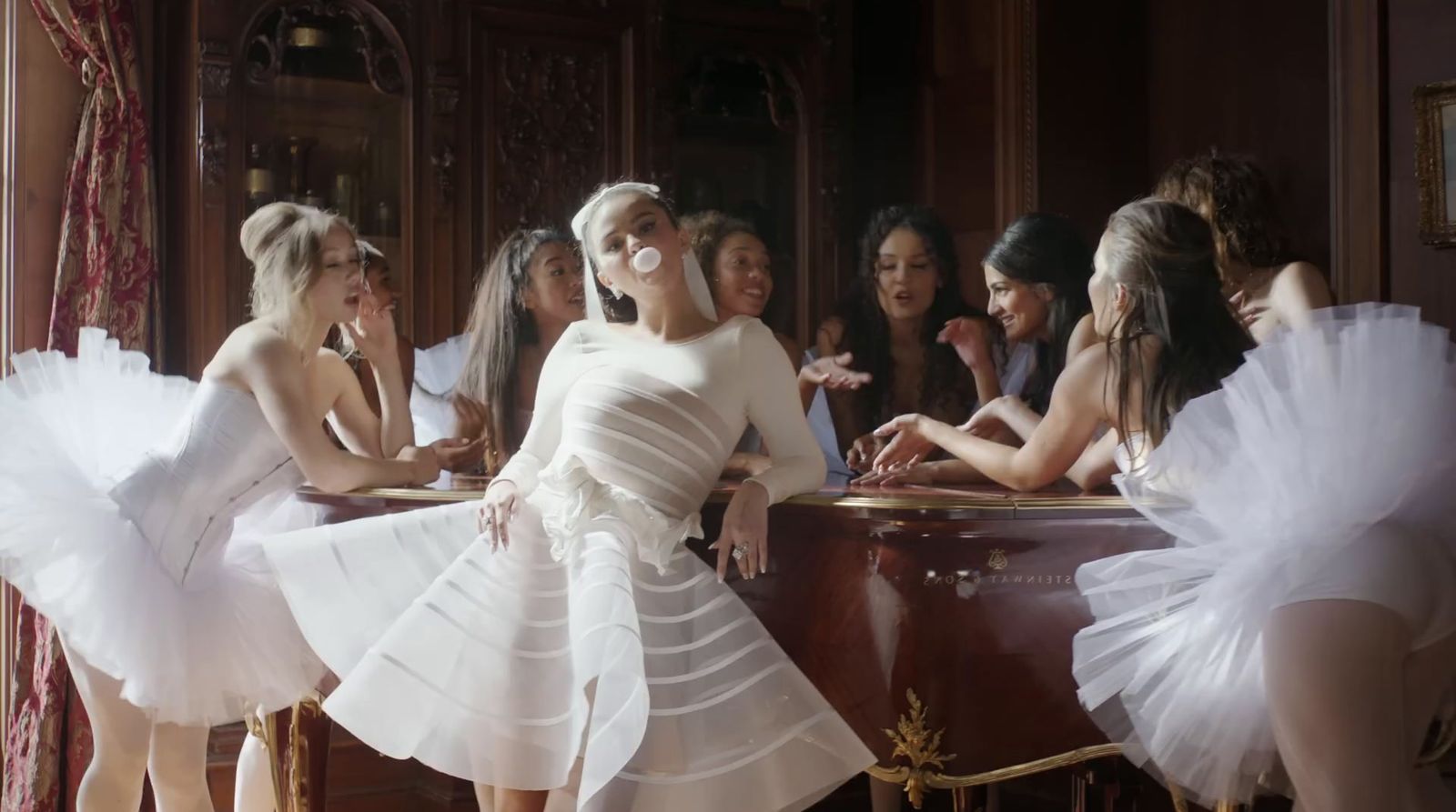 a group of women in white dresses standing in front of a mirror