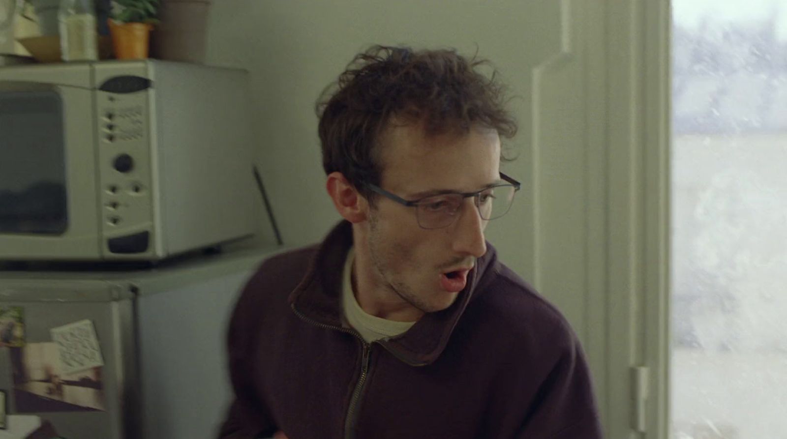 a man in a kitchen with a surprised look on his face