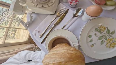 a table topped with a croissant and a cup of coffee