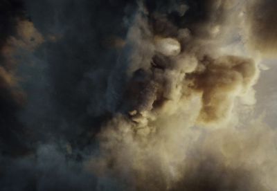 a plane flying through a cloud of smoke