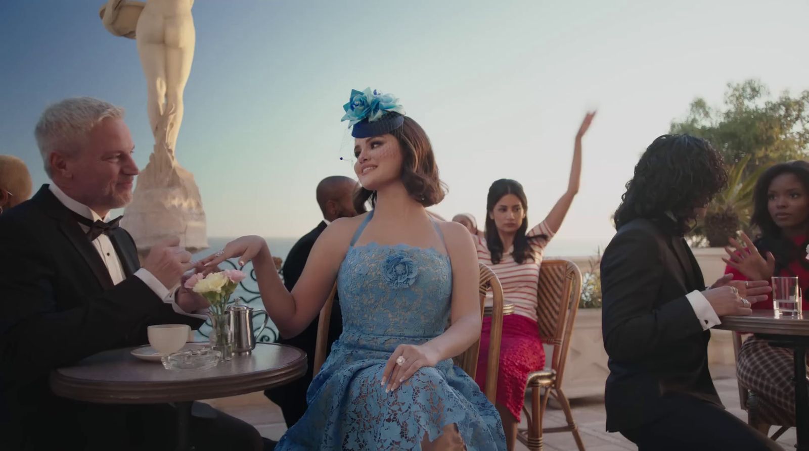 a woman in a blue dress sitting at a table