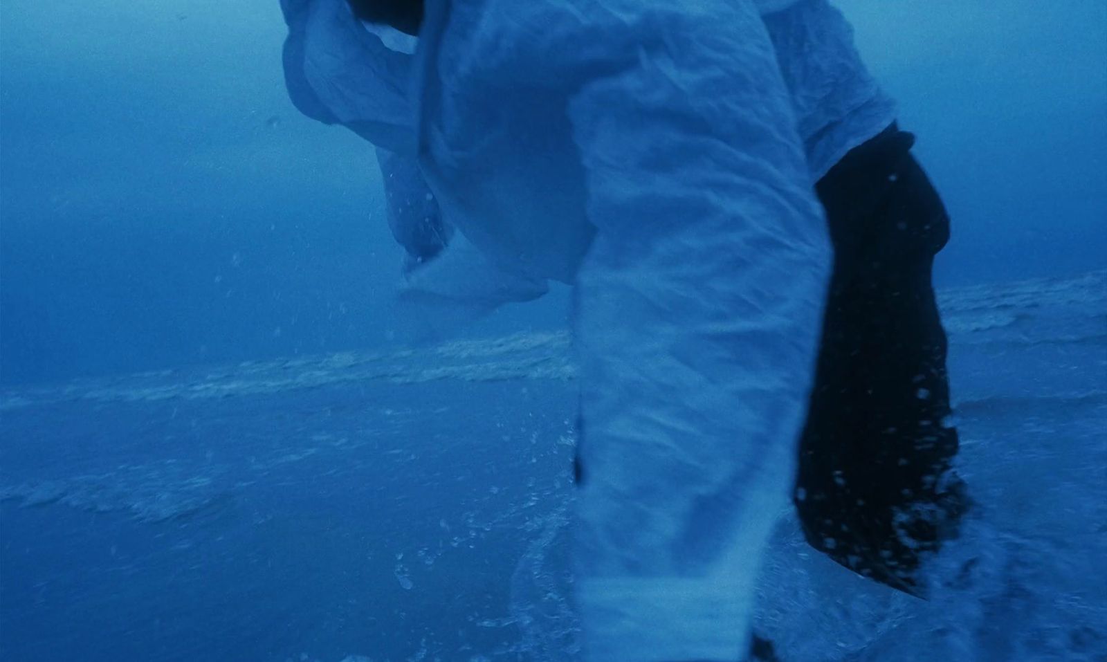 a man holding a fish while standing in the water