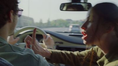 a man and a woman sitting in a car