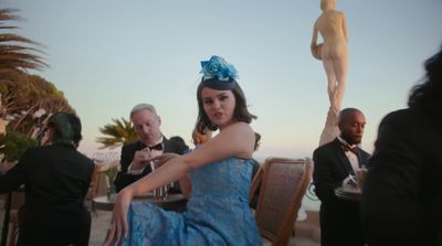 a woman in a blue dress sitting at a table