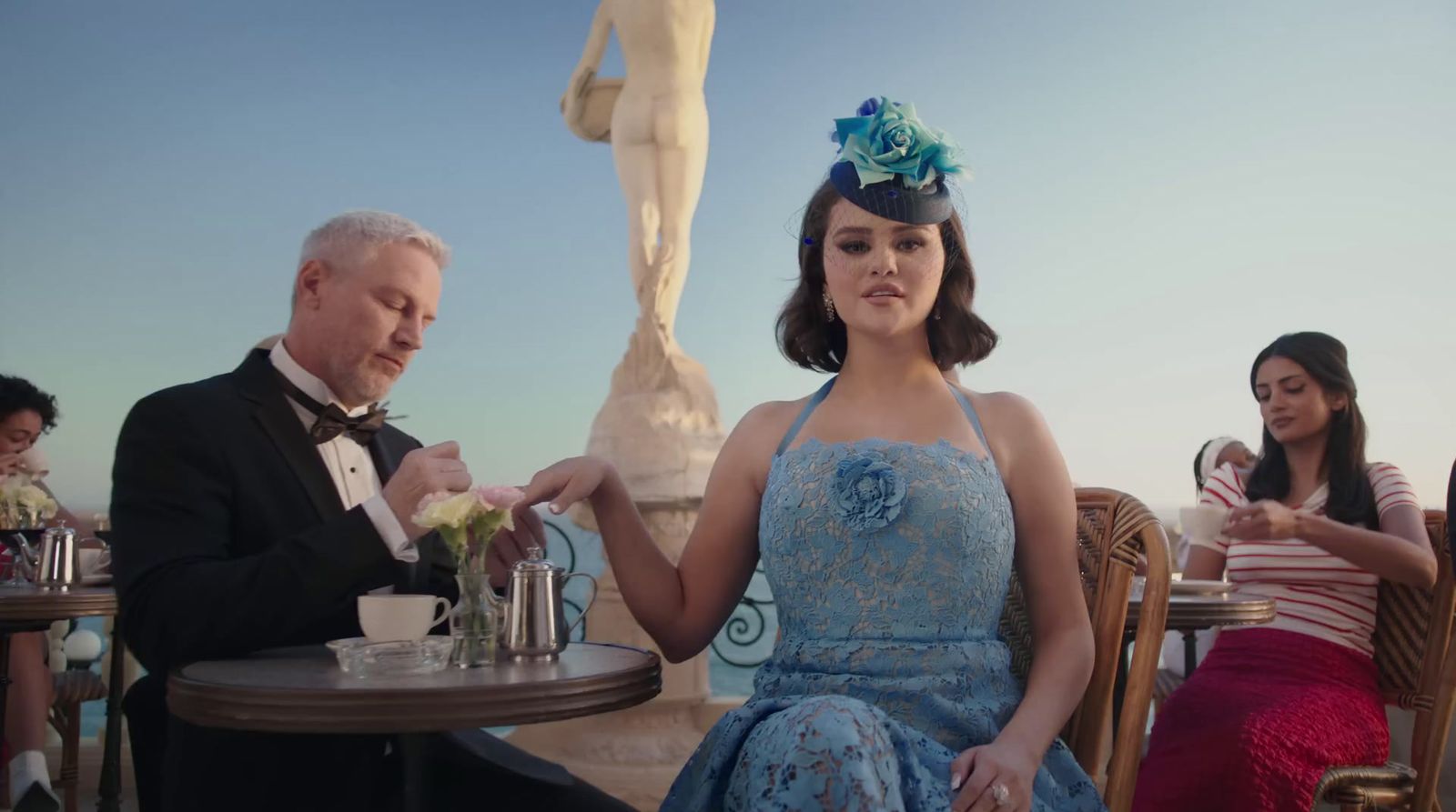 a woman in a blue dress sitting at a table