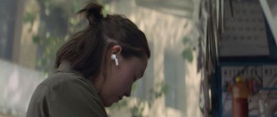 a girl with ear buds in a kitchen