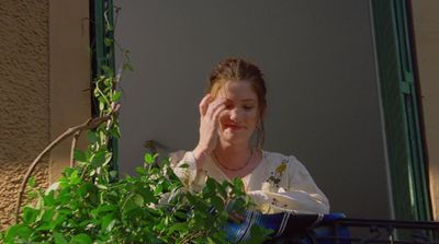 a woman holding her hand up to her face