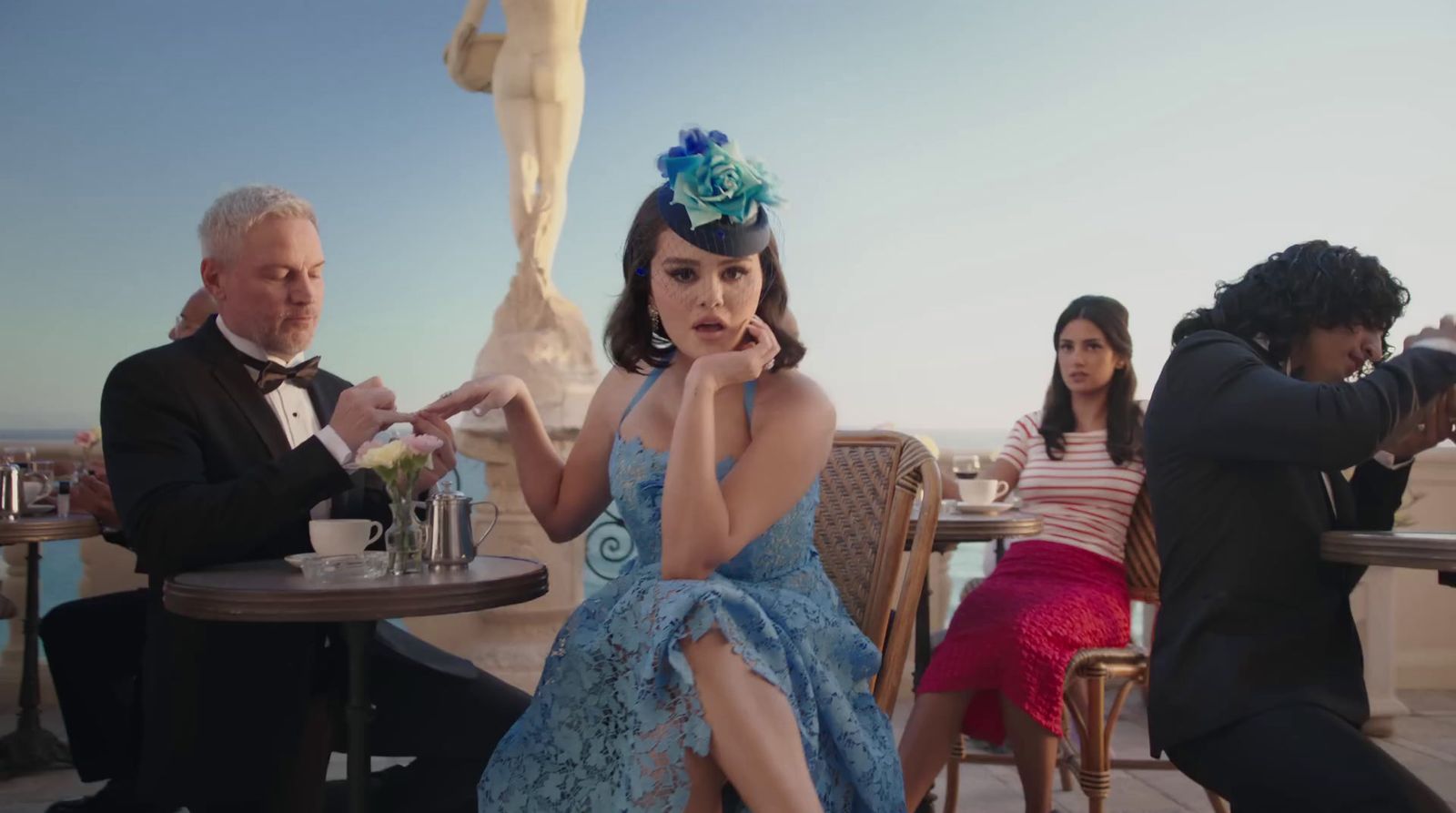 a woman in a blue dress sitting at a table