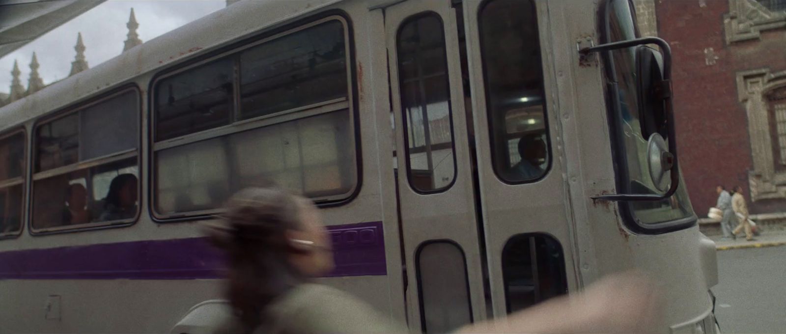 a woman is walking by a bus on the street