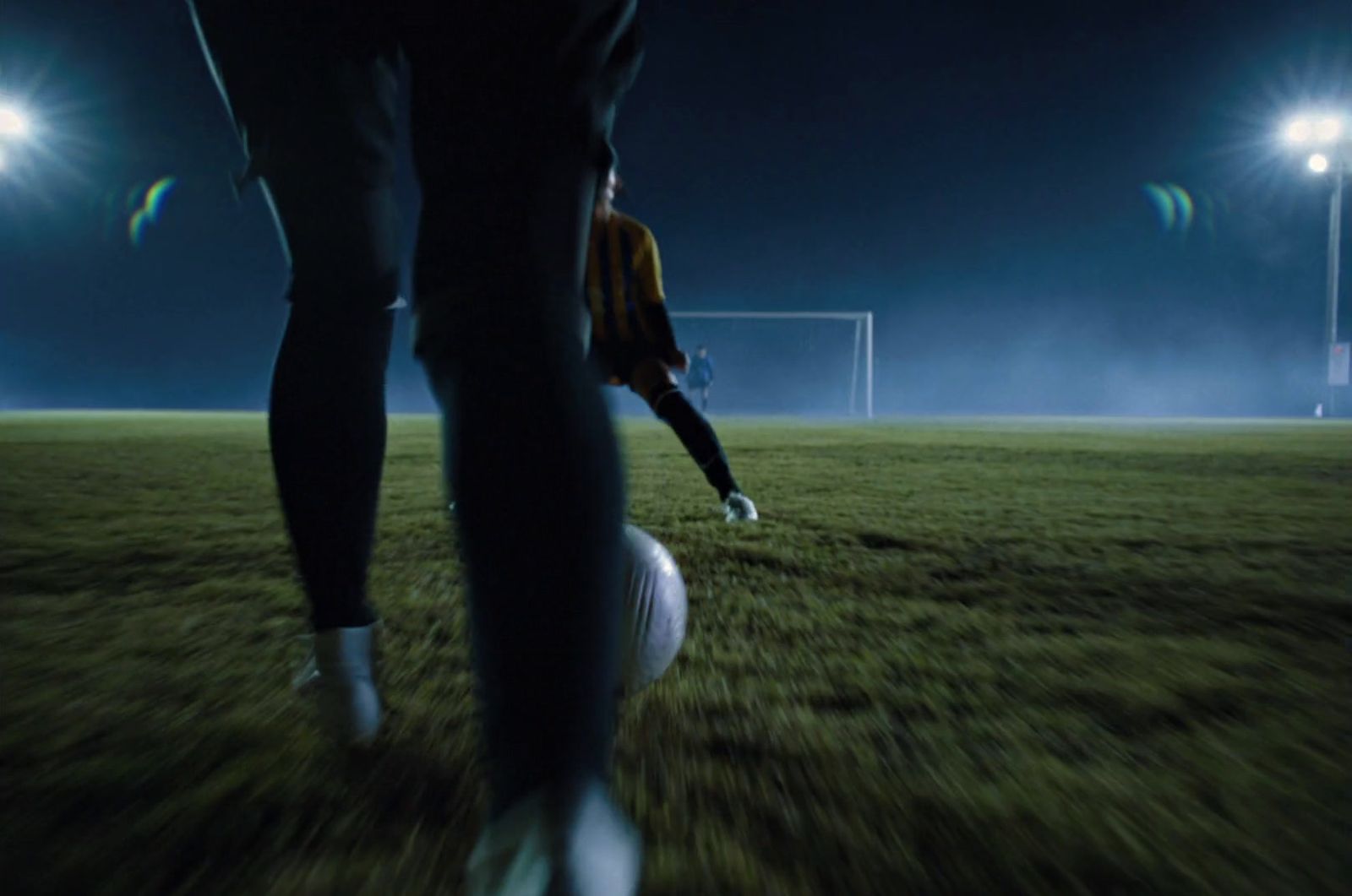 a person standing on top of a soccer ball on a field