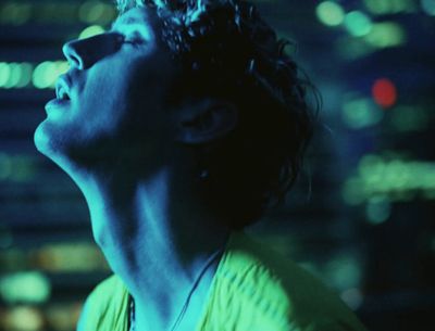 a man in a green shirt looking up at the sky