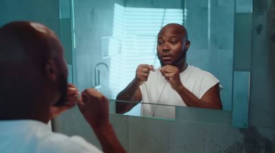 a man brushing his teeth in front of a mirror