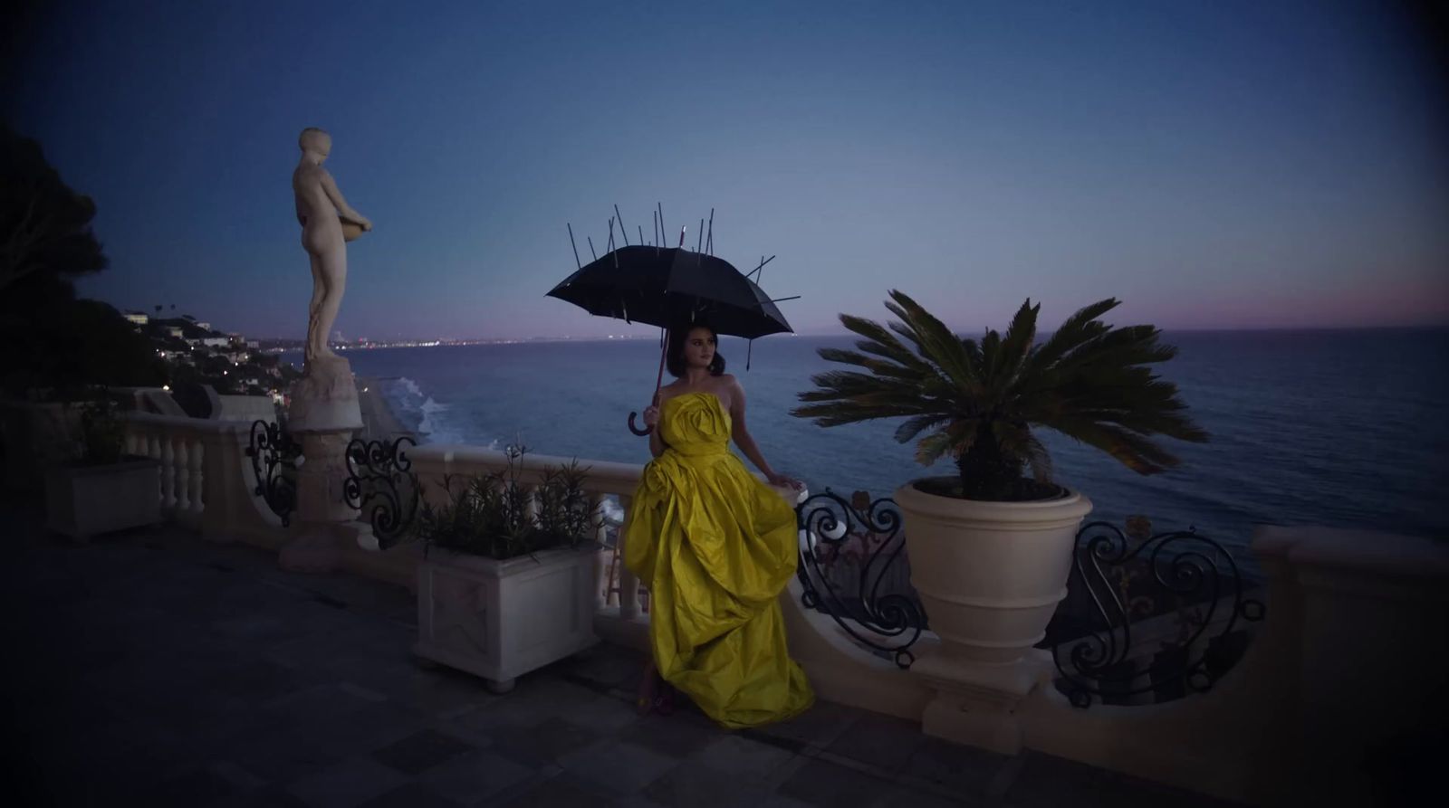 a woman in a yellow dress holding an umbrella