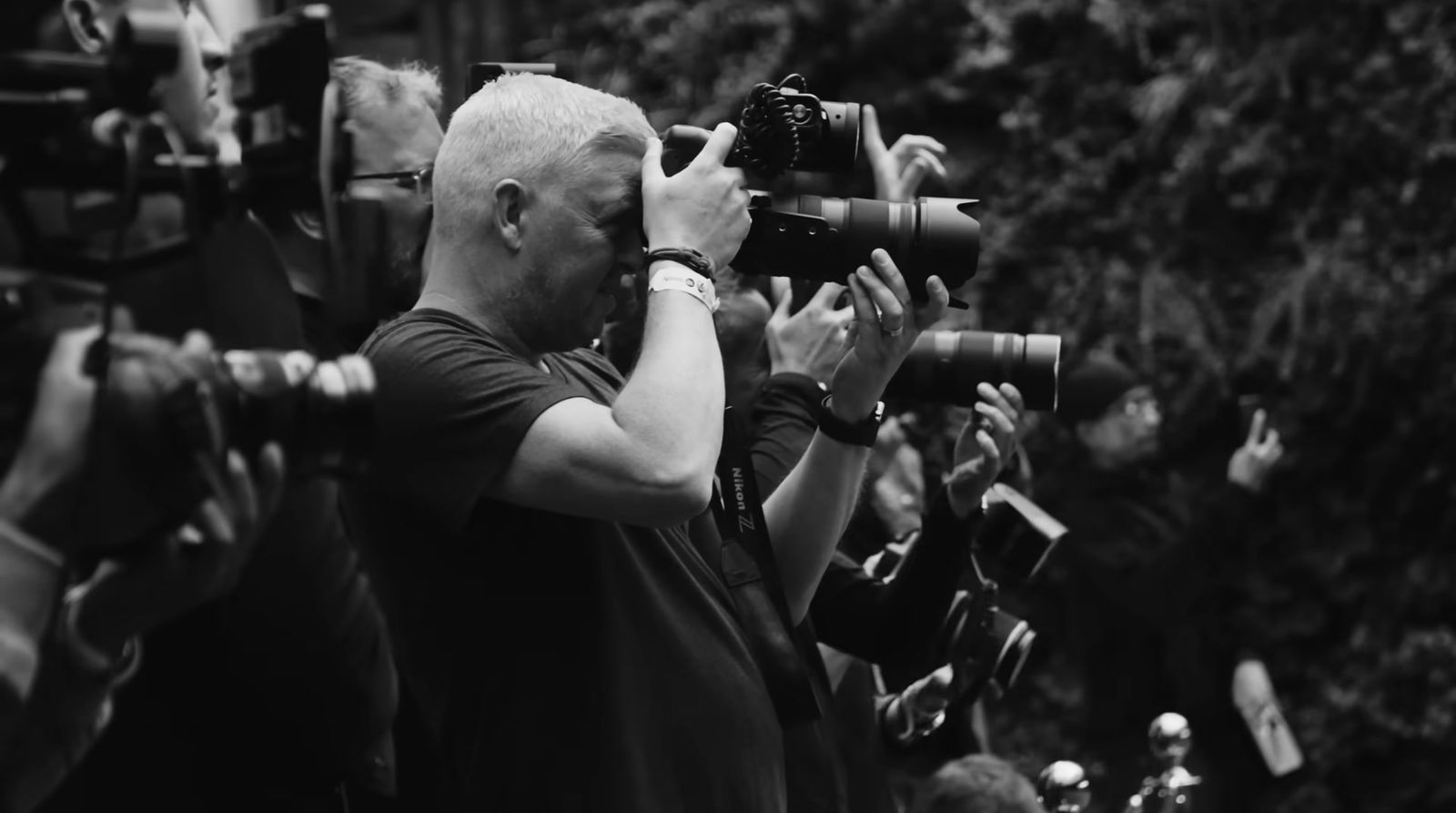 a black and white photo of a man holding a camera