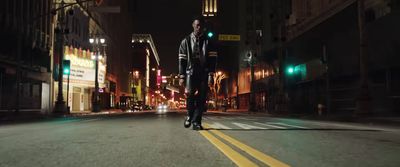 a man walking down a street at night