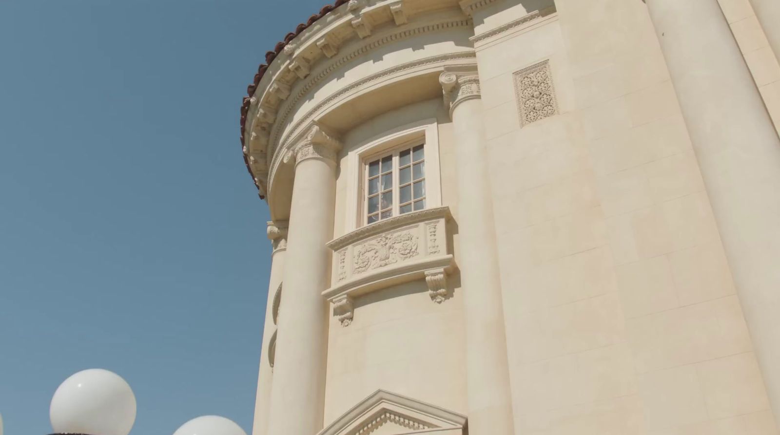 a tall white building with a clock on it's side