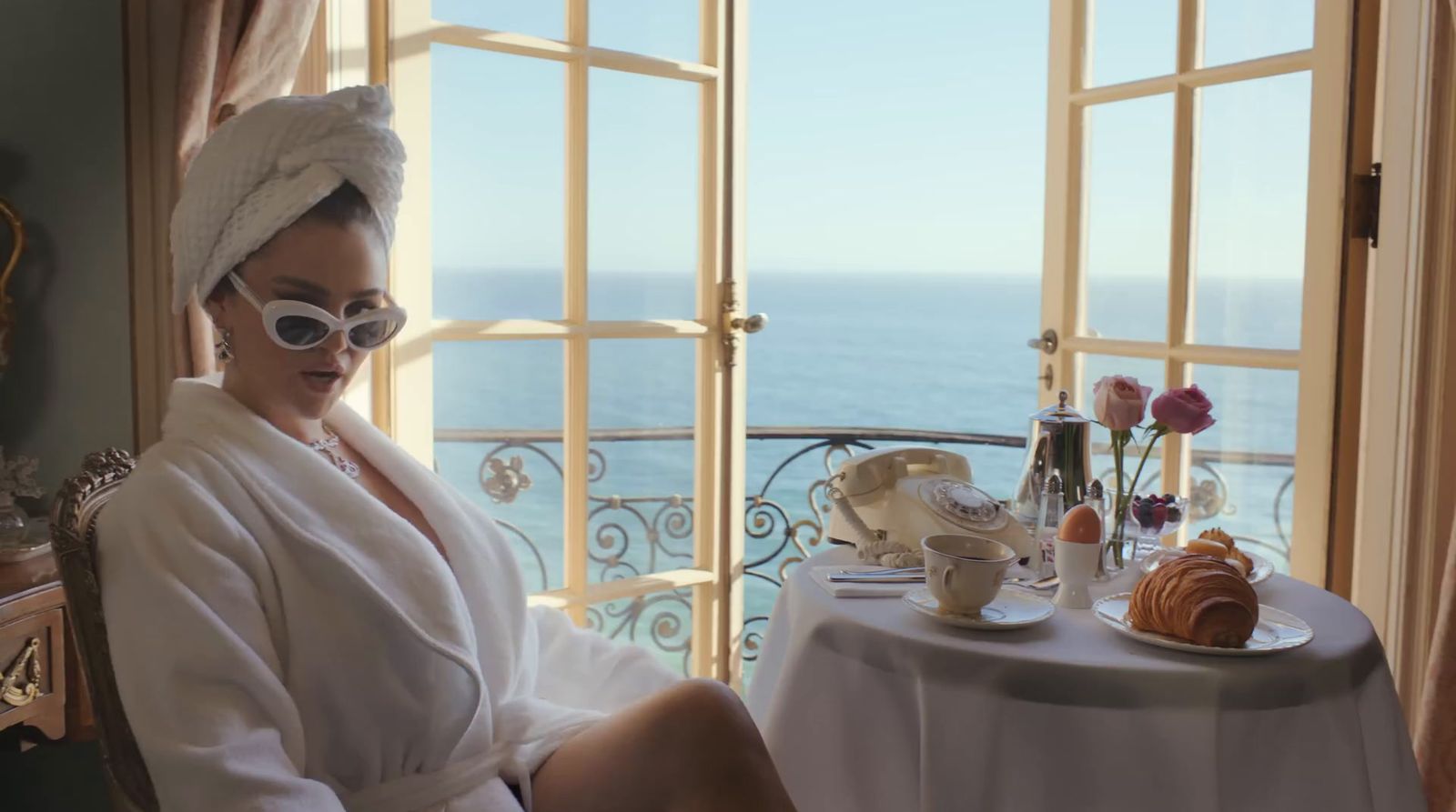 a woman in a bathrobe sitting at a table