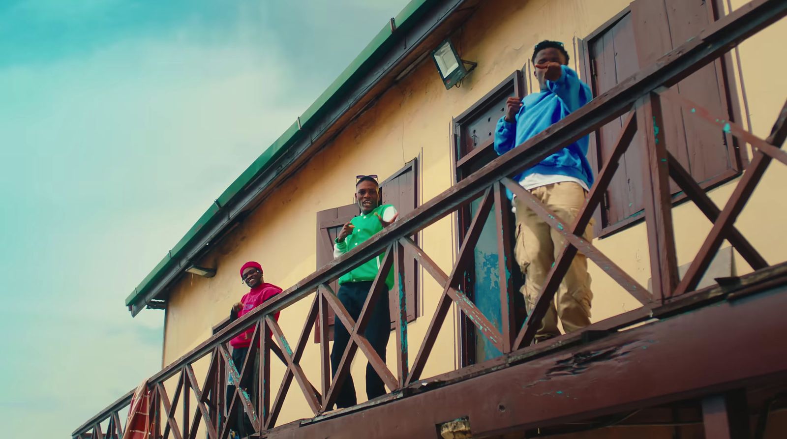 a group of people standing on a balcony next to a building