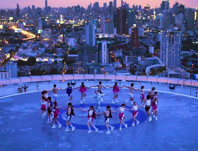 a group of people standing in a circle on top of a building