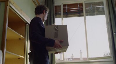 a man holding a box in front of a window