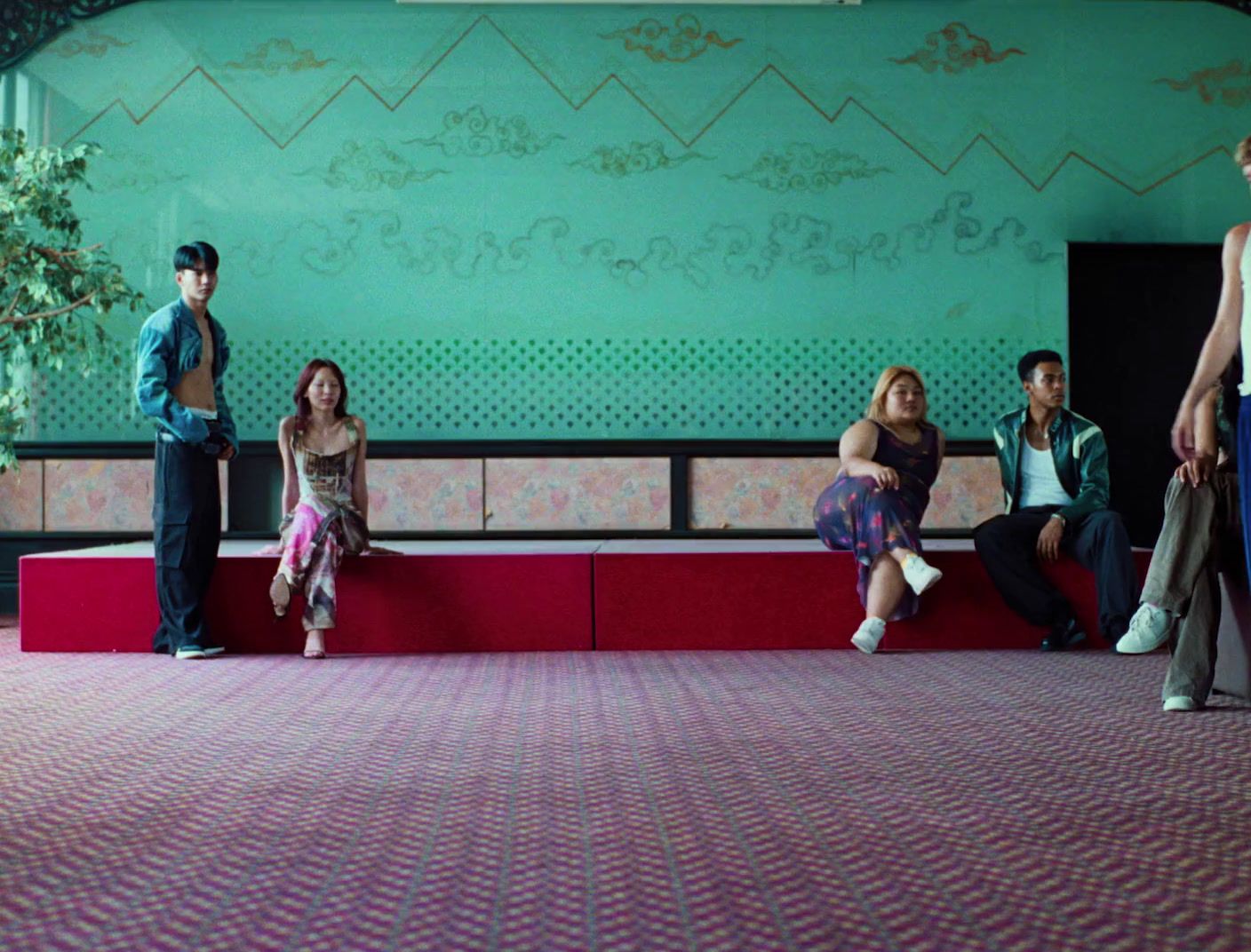 a group of people sitting on top of a red bench