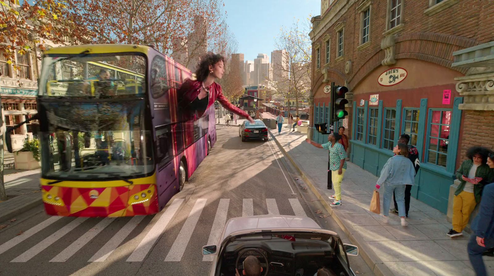 a group of people crossing a street in front of a bus