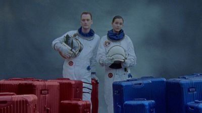 a couple of people standing next to some suitcases