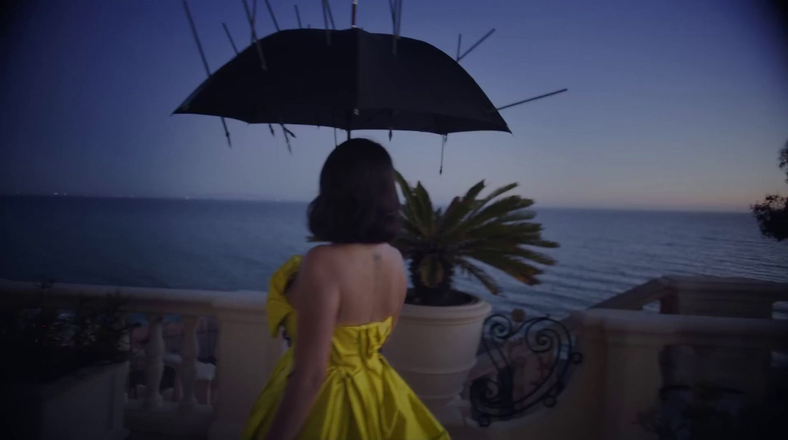 a woman in a yellow dress holding an umbrella