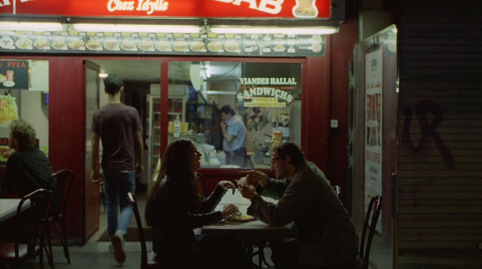 a group of people sitting at a table outside of a restaurant