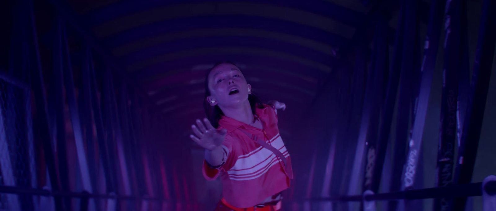 a woman standing in a tunnel with her arms outstretched