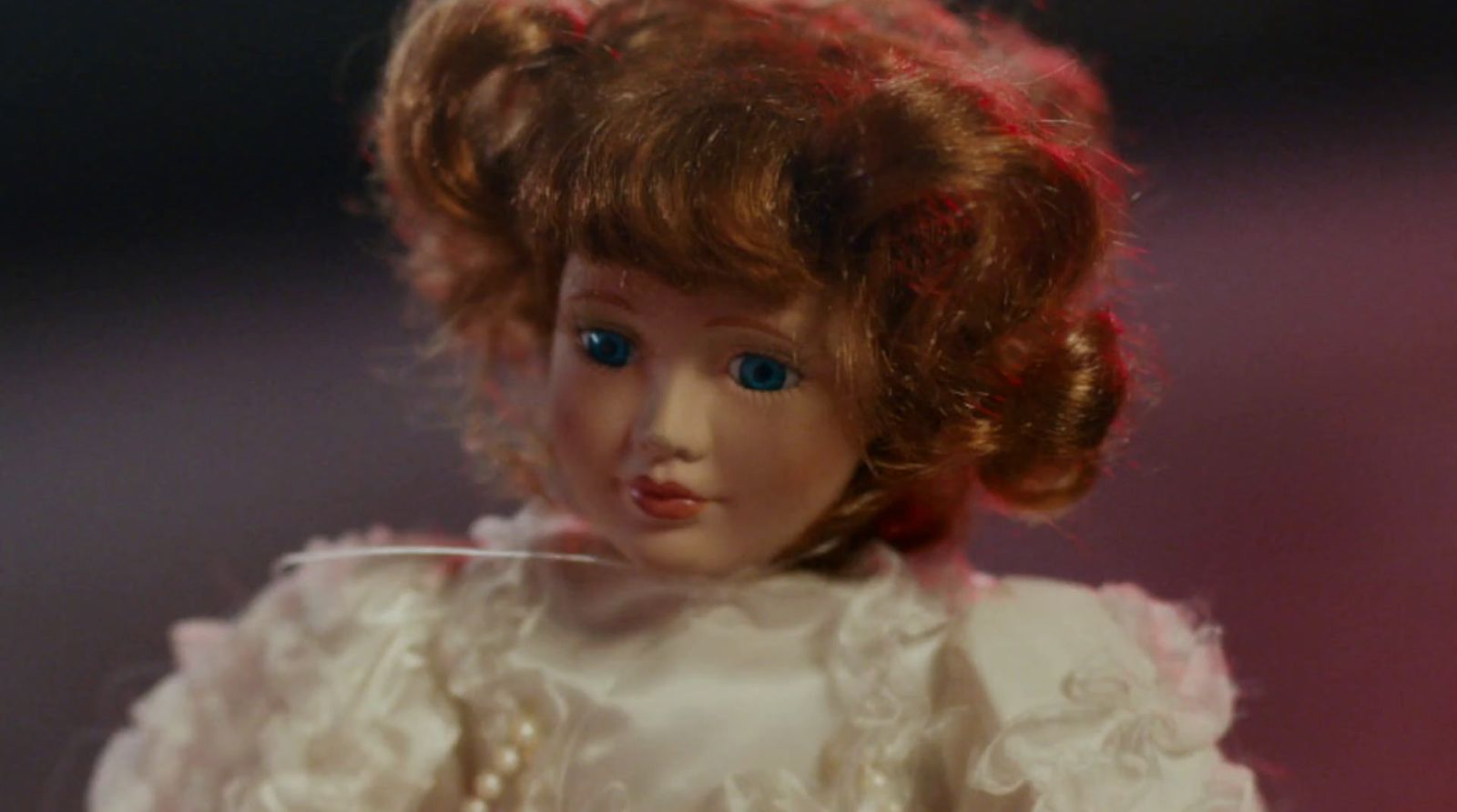 a close up of a doll wearing a white dress