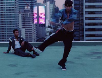 a man kicking a soccer ball on top of a roof