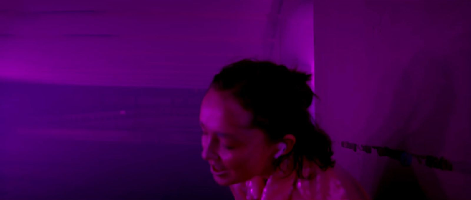 a woman in a dark room with a purple light