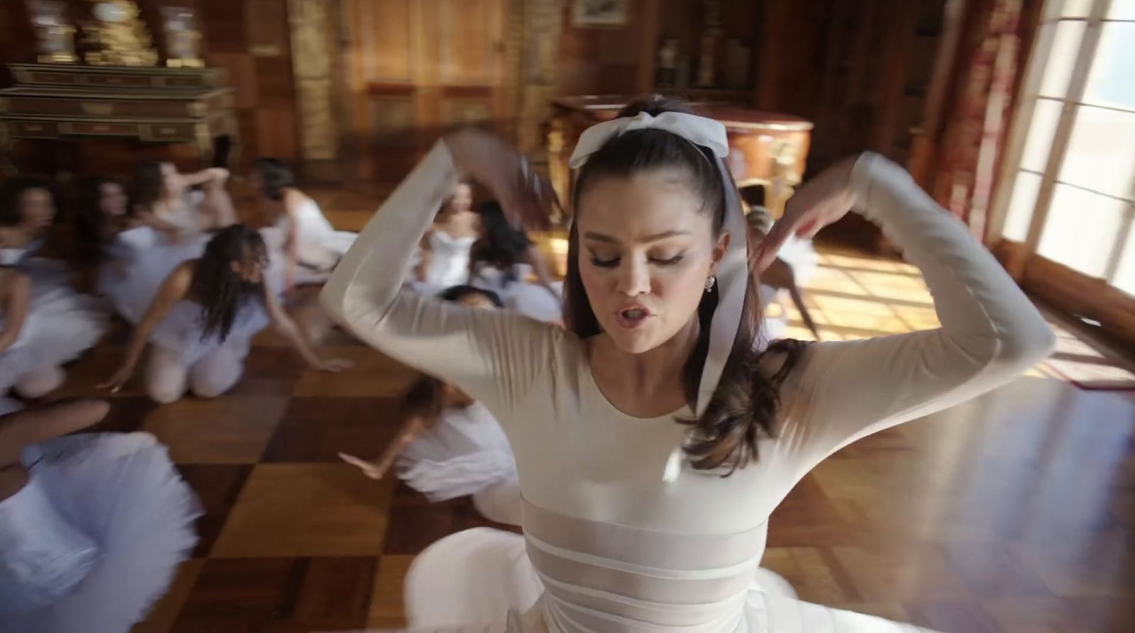 a woman in a white dress is dancing