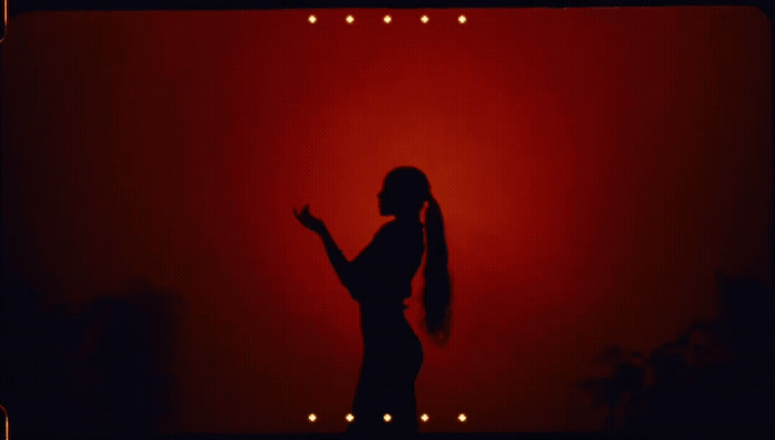 a woman standing in front of a red wall