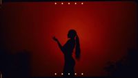 a woman standing in front of a red wall