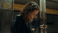 a woman sitting on a train looking at her cell phone