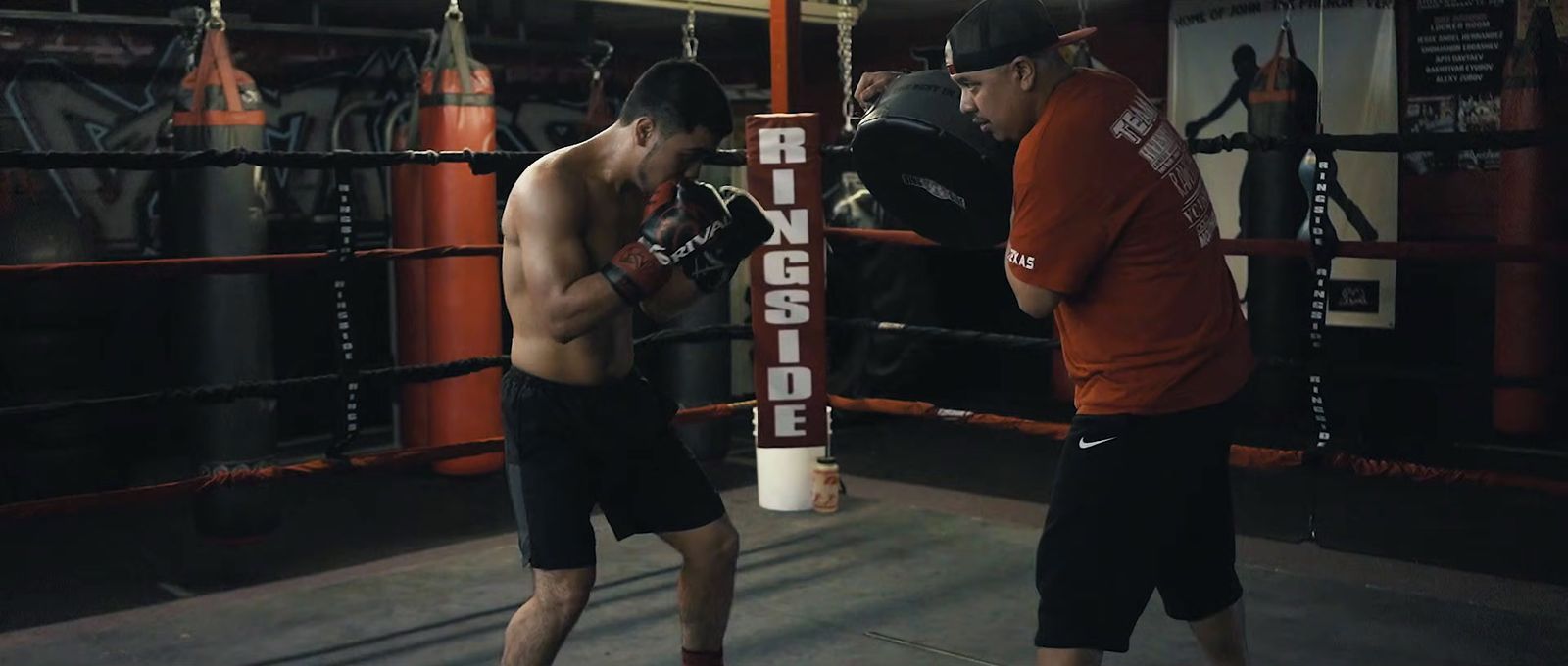 a man standing next to another man in a boxing ring