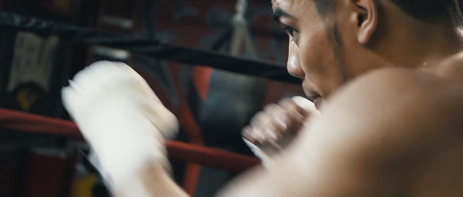 a shirtless man boxing in a boxing ring