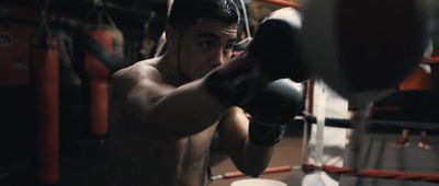 a shirtless man boxing in a boxing ring