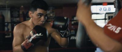 a young man wearing boxing gloves in a boxing ring