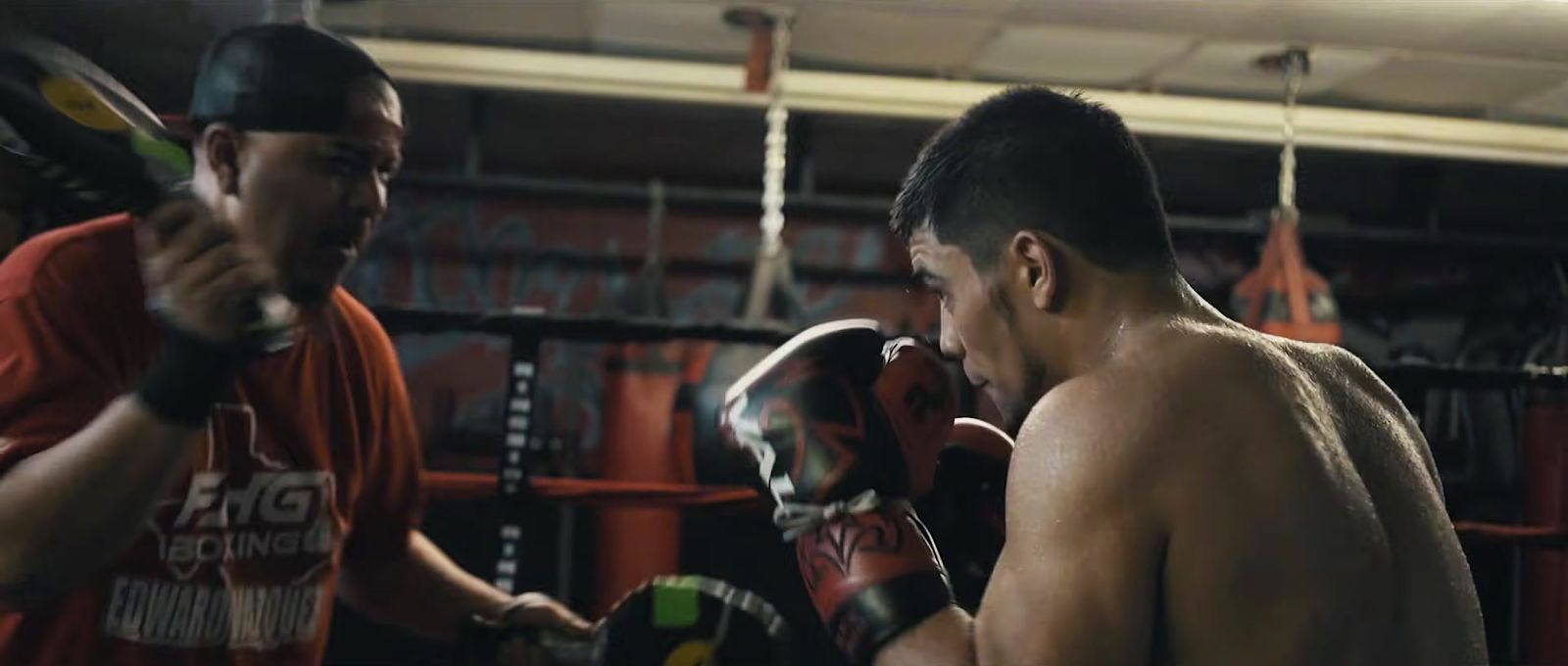 a man standing next to another man in a boxing ring