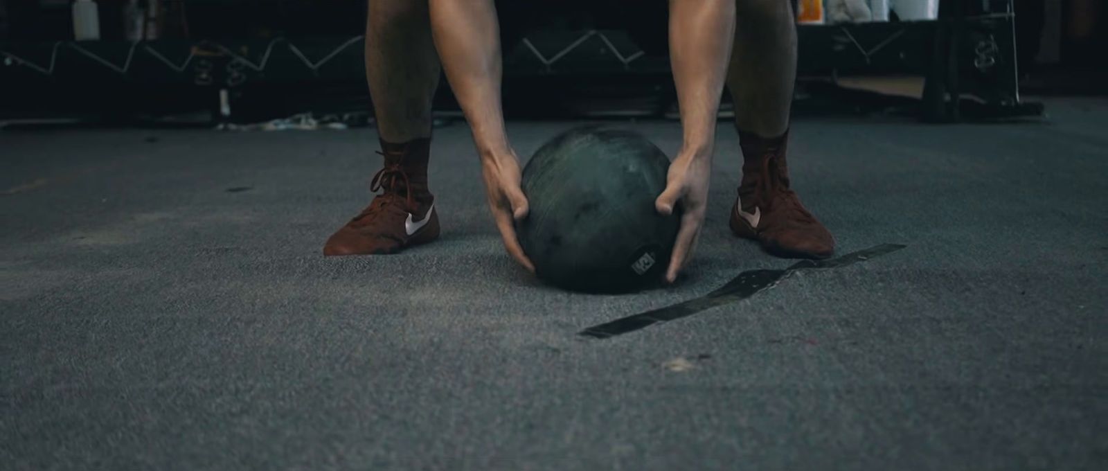 a person bending over to pick up a ball