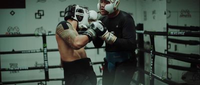 a man standing next to another man in a boxing ring