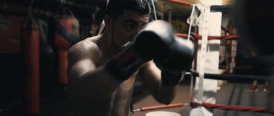 a shirtless man boxing in a boxing ring