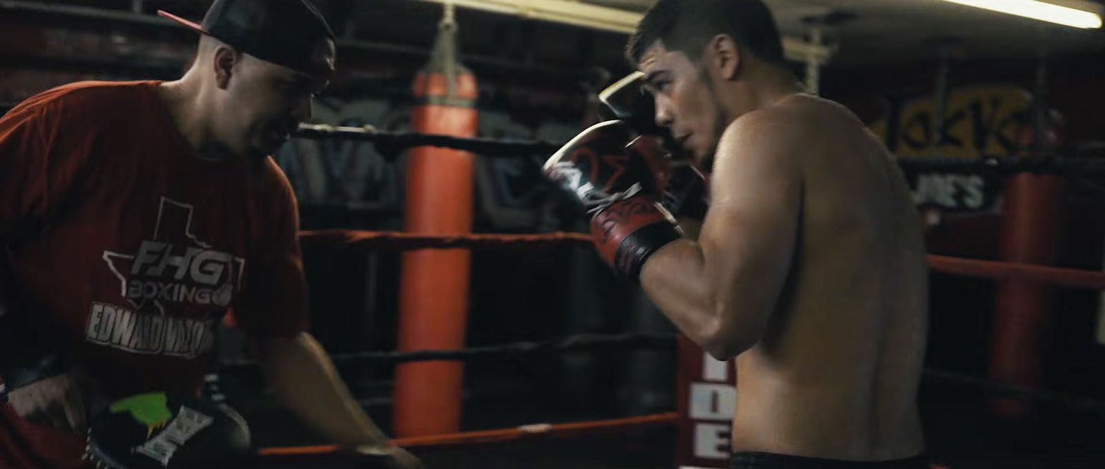 a couple of men standing next to each other in a boxing ring