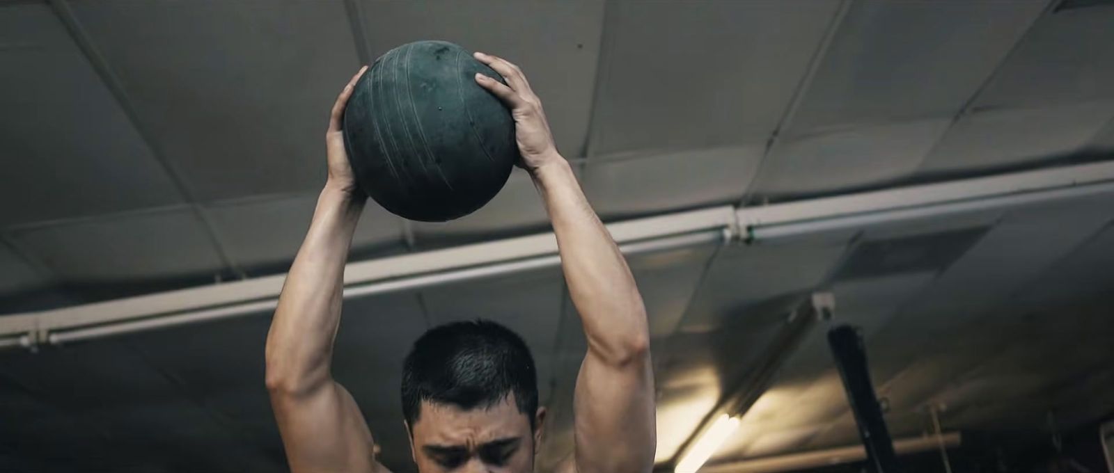 a man holding a green ball above his head